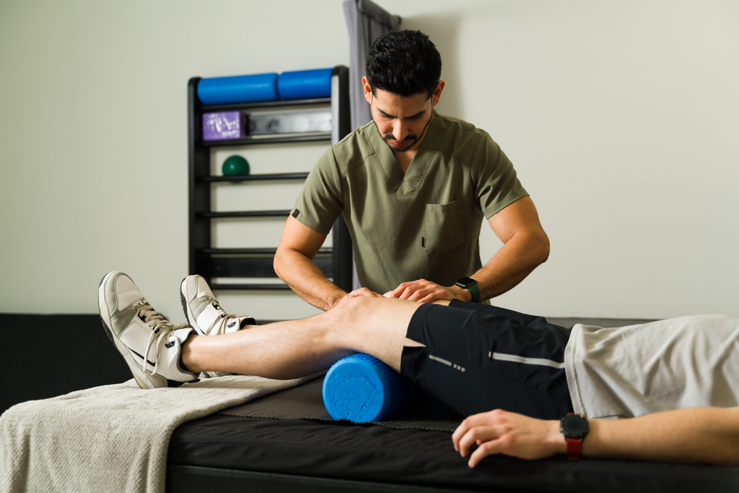 A physiotherapist treating a patient's shoulder in an Edmonton clinic