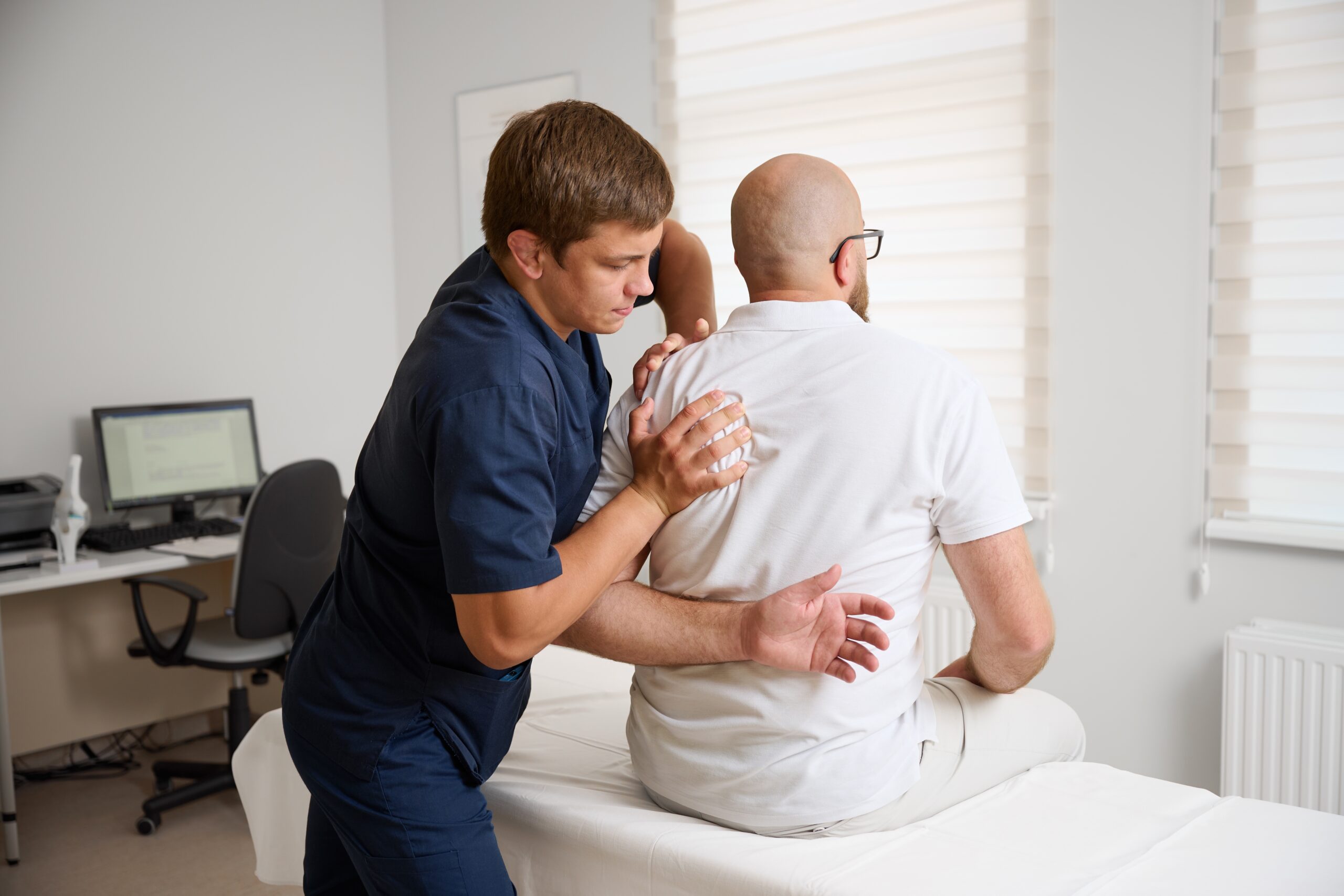 A physiotherapist treating a patient's shoulder in a Vancouver clinic