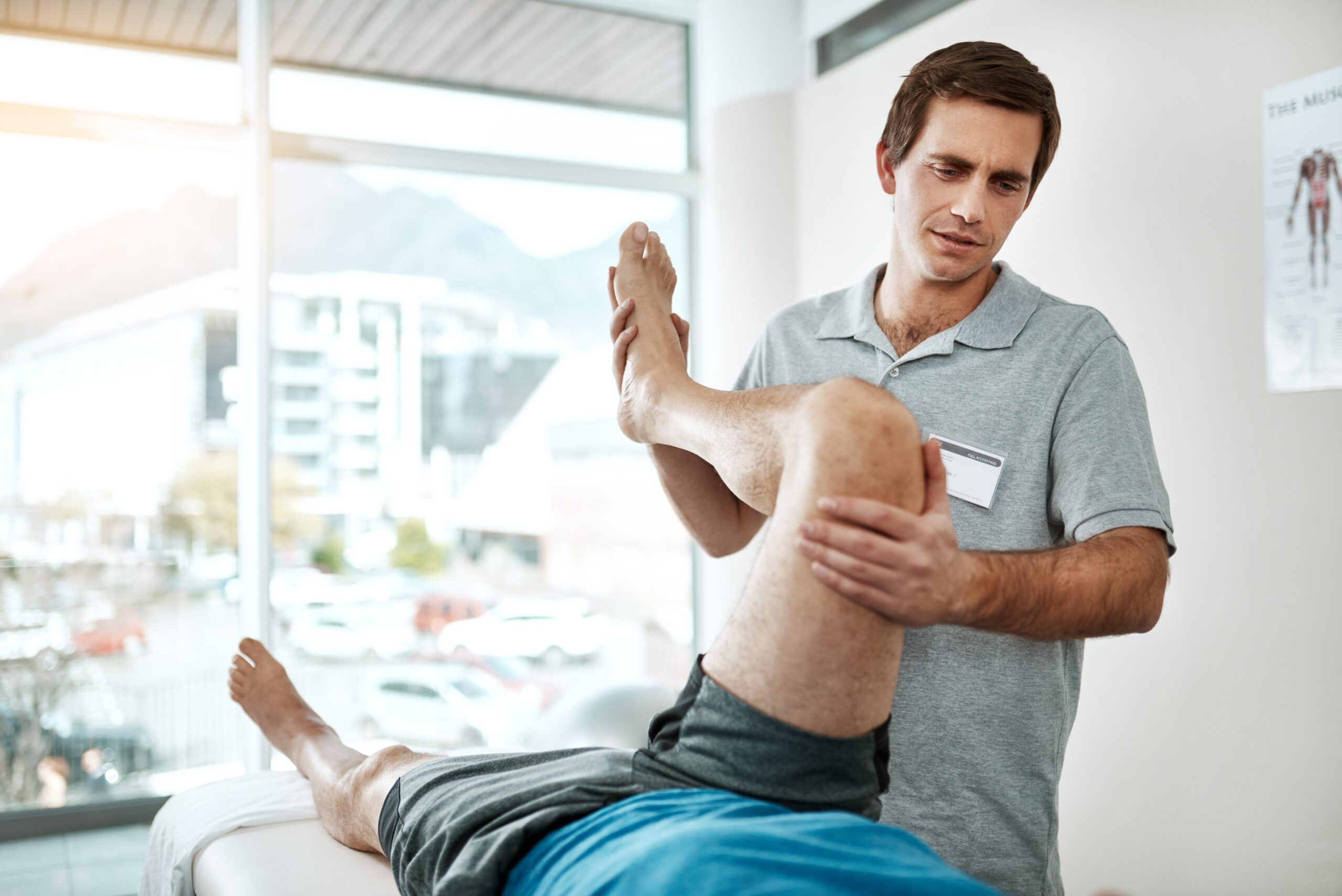 A physiotherapist treating a patient's shoulder in a Winnipeg clinic